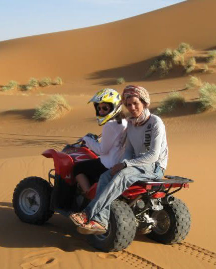 Joven conduciendo un quad en las dunas de Merzouga, una imagen que refleja los inicios de Sahara Buggy y su conexión con el desierto.